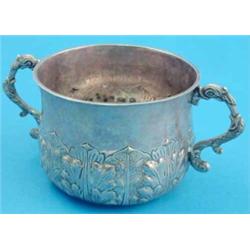 An Edwardian Britannia standard silver porringer with acanthus leaf decoration and scroll handles...