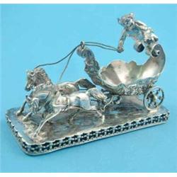 A Continental white metal model of a chariot with cherub overhead, 5ins....