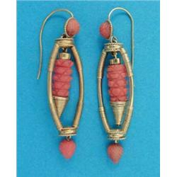 A near pair of gold and coral Etruscan design pendant earrings, with carved coral swing centres a...