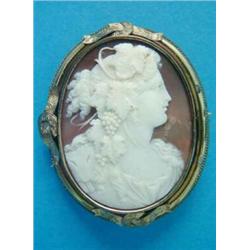 A Victorian shell cameo brooch, carved with a profile study of a bacchante, in rubover and ropetw...