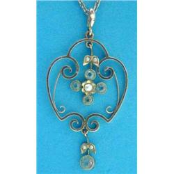 An Edwardian 9ct gold pendant, of openwork scroll design set aquamarines and seed pearls on fine...
