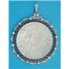 Image 1 : A gold and platinum mounted circular pendant, inset with a mother of pearl plaque carved with a s...