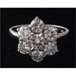 A white gold flower cluster ring set with brilliant cut diamonds, the centre stone weighing appro...