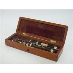 A MAHOGANY CASED PICCOLO, ebony with nickel mounts  £30-40...