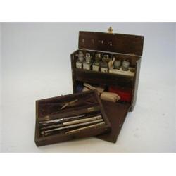 AN EDWARDIAN WOODEN MEDICINE BOX, comprising labelled glass bottles and related equipment, lancet...