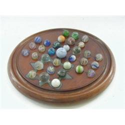 A MAHOGANY SOLITARE BOARD, early 20th century, with marbles with various inclusions, in a box  £2...