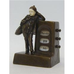 A BRONZED ART DECO DESK CALENDAR, 1920's, formed as a standing Pierrot beside dog and date apertu...