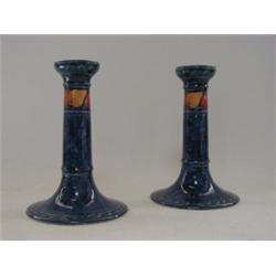 A PAIR OF KEELING & CO CANDLESTICKS, 'Losol Ware', painted fruit on a mottled blue ground, height...