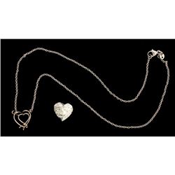 NECKLACE:  [1] Platinum oval rolo chain necklace with a center setting set with a heart shaped diamo