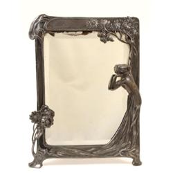 A WMF Table Mirror, within a border decorated whiplash, foliage and a lady, 37 cm  See illustrati...