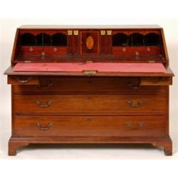 A George III Mahogany Bureau, the fall front enclosing a fitted interior, with central inlaid urn...