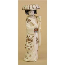 CARVED AND POLYCHROMED IVORY FIGURE OF A GEISHA, Japanese. Signed. The walking female wearing a...