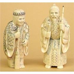 PAIR OF CARVED IVORY FIGURES, Japanese. Signed in a cinnabar seal. Of an elderly man holding a...