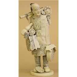 CARVED IVORY FIGURE OF A PEDDLER, Japanese. Signed. Carrying his wares on a bamboo pole and in...