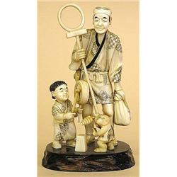 CARVED IVORY GROUP, Japanese. Depicting an entertainer with his child assistant and a monkey. M...