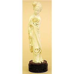 CARVED IVORY FIGURE OF A BEAUTY, Chinese. Signed. In a standing position holding a chrysanthemu...
