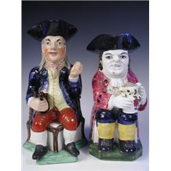 A late 18th Century/early l9th Century Toby jug and a 19th Century Squire Toby jug each holdin...