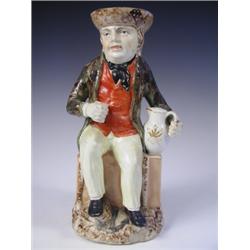 A late 18th/early 19th Century Sailorman Toby jug, having a mottled brown glaze hat and mottle...