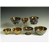 Image 1 : Seven copper lustre bowls, each with blue or mustard bands of decoration, two with moulded flo...