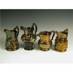 Four copper lustre jugs, two with moulded figures, one of shaped baluster form and one of plai...