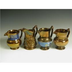 Four copper lustre jugs, three of baluster shape with coloured bands, and one moulded with dan...