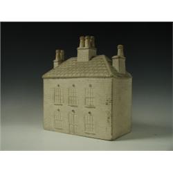 A 19th Century unglazed pottery model of a house, with incised architectural details, 28cm hig...