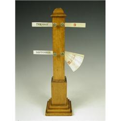A late 19th Century oak signpost desk calendar with ivory markers. Impressed registration stam...