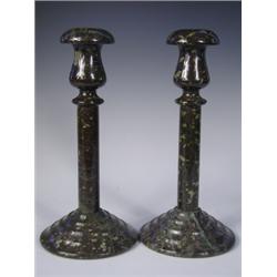 A pair of serpentine marble candlesticks, with tulip shaped sconces and circular stepped base,...