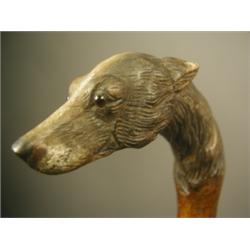 A Victorian walking stick, the top carved and painted with a dogs head, on a bark shaft, 90cm...