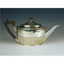 A Victorian silver oval teapot, with half gadrooned decoration, an ebonised handle and knop, m...