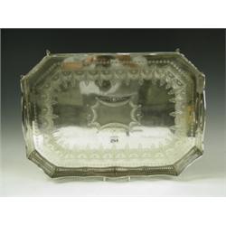 A late Victorian silver tray with pierced gallery and engraved swag decoration, on eight scrol...