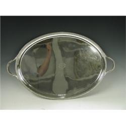 An oval silver tray in the neo classical style with an engraved monogram, gadrooned borders an...