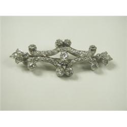 A diamond scroll brooch set with old cut stones, set in white metal (tests platinum), 55cm lon...