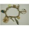 Image 1 : A 14ct gold charm bracelet with 10 various charms, 18cm long Est. 100/150...