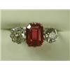 Image 1 : A three stone ring set with a central trap cut synthetic ruby and two old cut diamonds in plat...