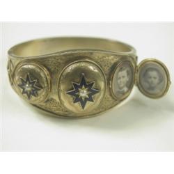 A Victorian memorial hinged bangle with 3 double photo lockets to the top, each set with a cul...