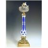 Image 1 : A Victorian oil lamp with a white overlaid blue glass column on a cast bronze base, 69cm high<...