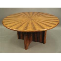 A modern Gordon Russell circular table, the top in segmental rosewood veneer, on a cross shape...