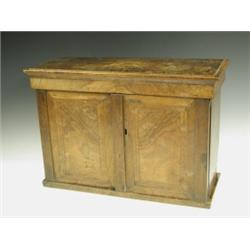 A small walnut veneered on oak shelf cupboard, the top with an inlaid star motif duplicated to...