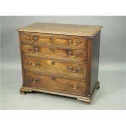 A George III mahogany chest with four graduated drawers between fluted and canted corners, on...