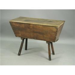 An early 19th Century elm dough bin with a shaped wavy apron supported upon four inverted tape...