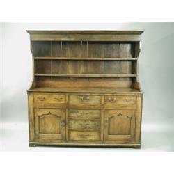 A late 18th Century oak country dresser, with a reduced and altered plate rack over three frie...