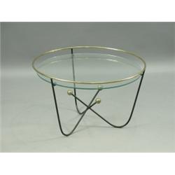 A 1950's iron and brass 'Atom' table, with a circular glass top, retailed by Heals, 66.5cm dia...