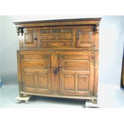 An early 18th Century oak Duodarn, the upper section with a cupboard at each side with drawers...
