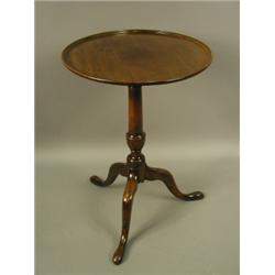 A late 18th Century circular mahogany tripod table, c1790, the dished top hinged on a vase sha...