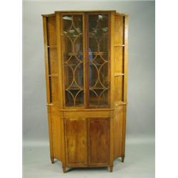 An Edwardian satinwood bookcase with two astragal glazed doors and shaped open shelves over tw...