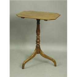 An early 19th Century mahogany tripod table, the cut corner rectangular top on a turned beechw...