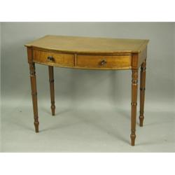 A George III mahogany bowfront sidetable, with ebonised stringing and two drawers on turned le...