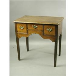 An 18th Century mahogany lowboy, with three short drawers above a shaped apron with similar sh...