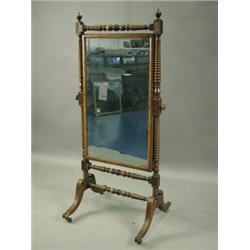 A Regency mahogany cheval mirror, with urn shaped finials surmounting the bobbin-turned and pa...